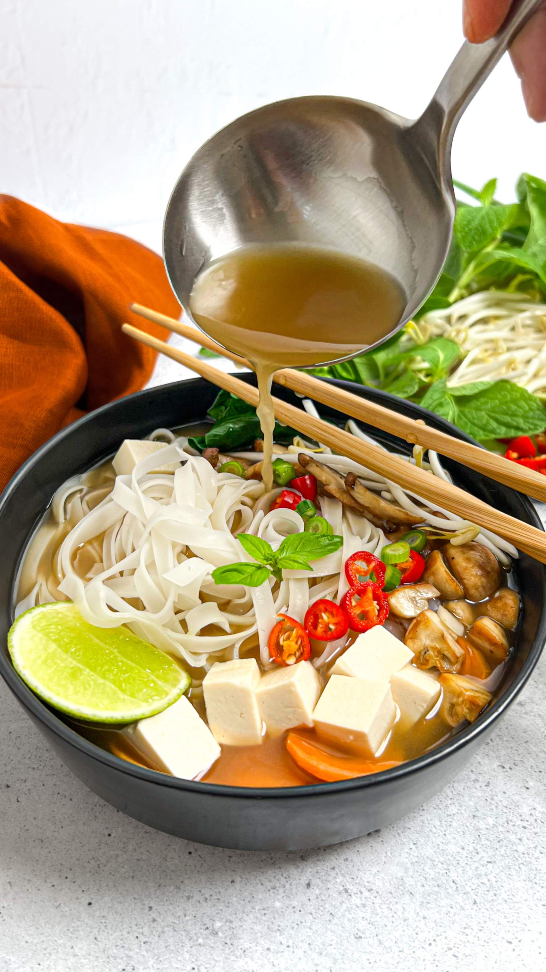 Heartful Flavours Vietnamese Pho Recipe Lifestyle Shot with Pho Broth pouring from ladle